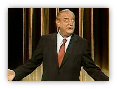 "Comedian performing on stage with a surprised expression."