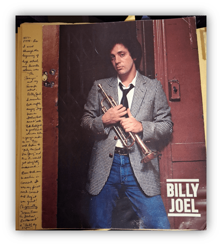 Billy Joel holding a trumpet, 1970s vintage photo with handwritten notes.