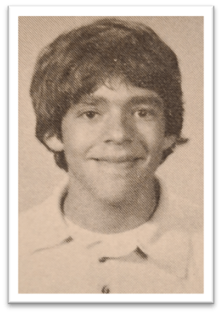 "Black and white portrait of a smiling young boy with a short hairstyle wearing a collared shirt."