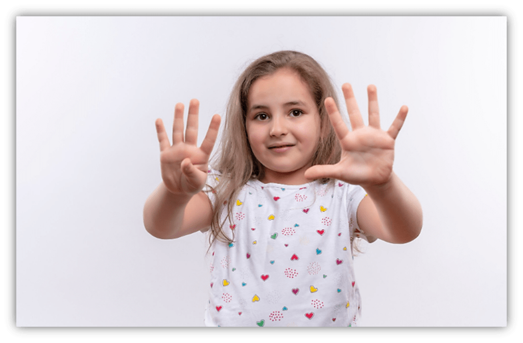 Young girl showing ten fingers, smiling against a white background.
