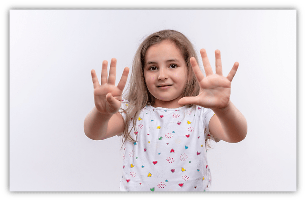 Young girl showing ten fingers, smiling against a white background.
