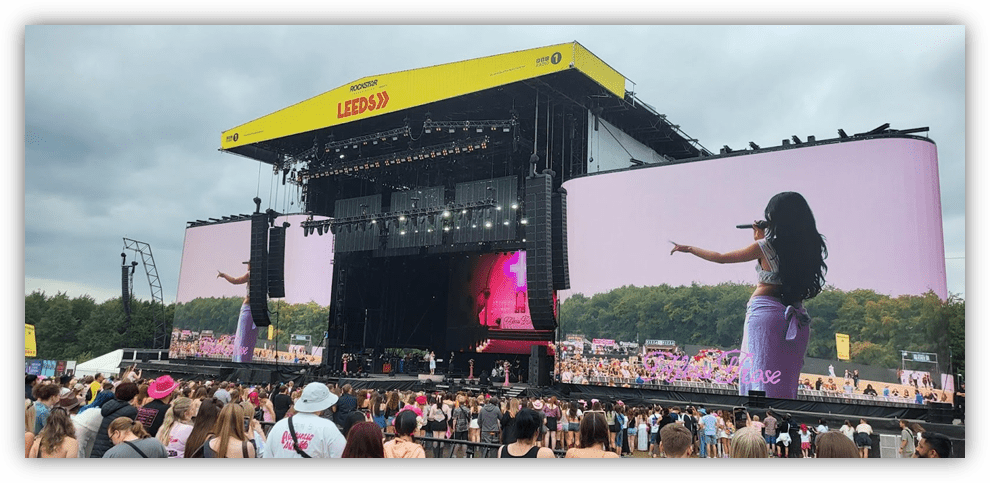 Crowd at Leeds Festival watching a performer on a large screen.