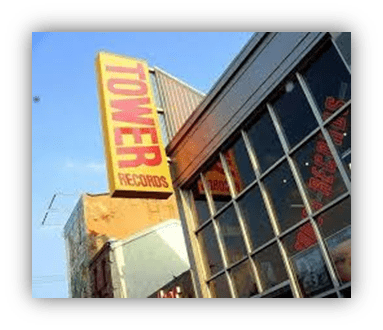 "Tower Records storefront with vibrant signage against a clear blue sky."