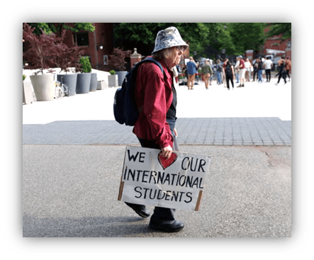 "Protester holding sign supporting international students on campus."