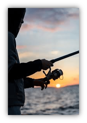 Person fishing at sunset with a fishing rod.