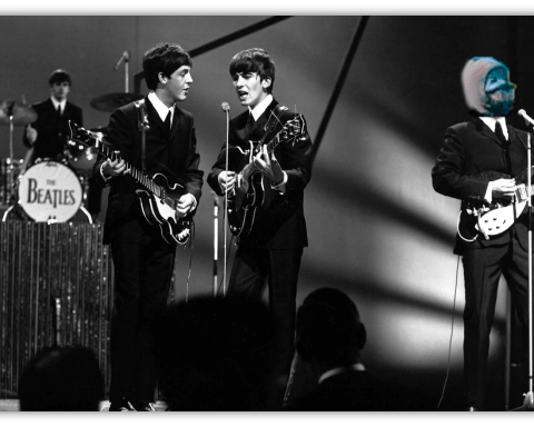The Beatles performing live on stage in black and white.