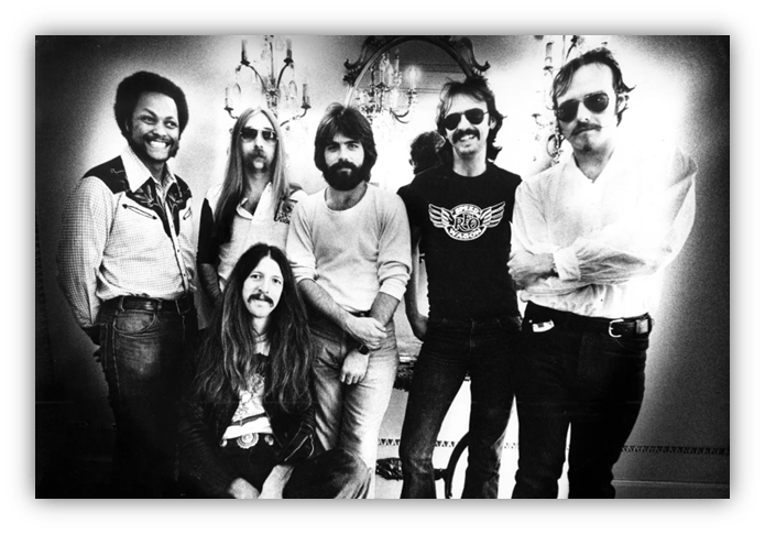 "Black and white photo of a 1970s rock band posing together in a vintage setting."