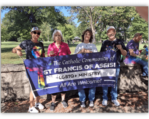 Four people holding a banner for St. Francis of Assisi LGBTQ+ Ministry, promoting inclusivity in a park setting.