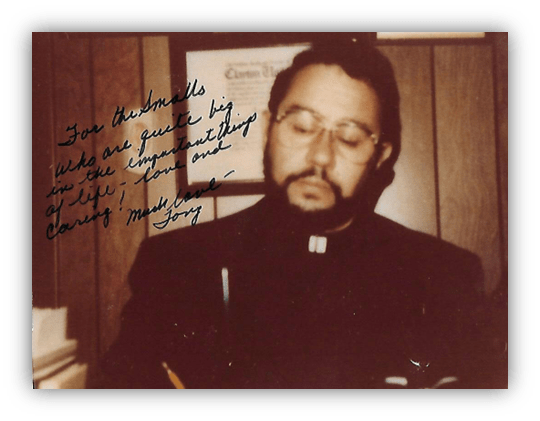 "Man in clerical attire writing a note, with a heartfelt message in the background."