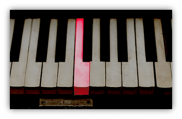 "Close-up of piano keys with one highlighted in red."
