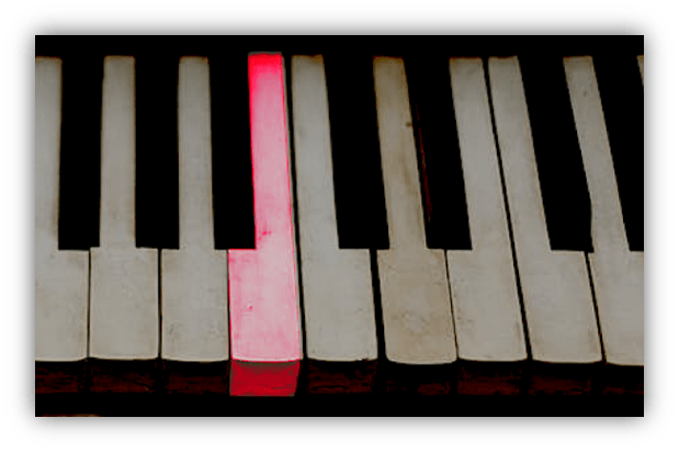 "Close-up of piano keys with one red-highlighted key."