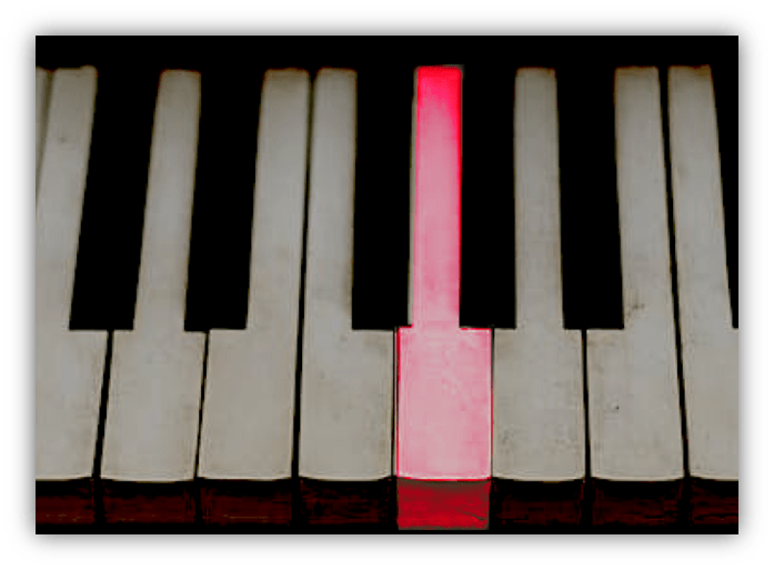 Red piano key among black and white keys.