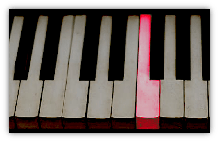 Close-up of piano keys with one red key highlighted.