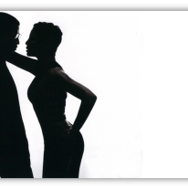 Silhouette of a couple in an intimate pose against a white background.