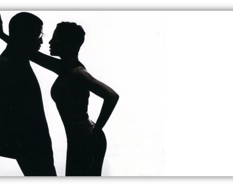 Silhouette of a couple in an intimate pose against a white background.