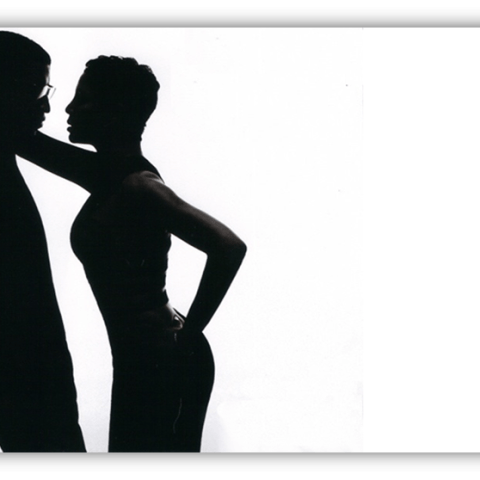 Silhouette of a couple in an intimate pose against a white background.