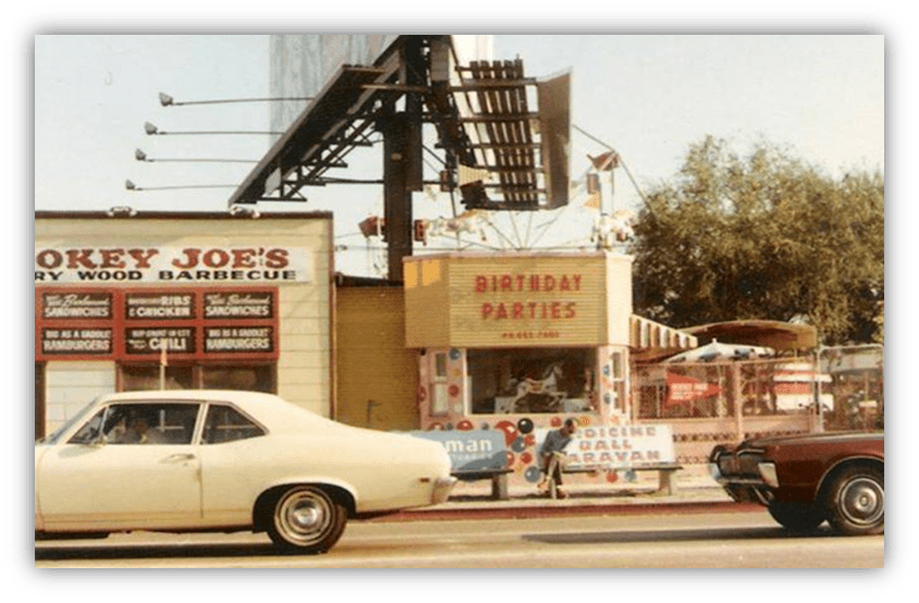 "Vintage street scene featuring Smokey Joe's Barbecue and a birthday party venue."