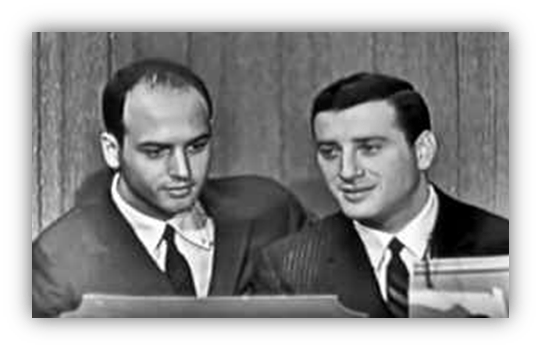 Two men in suits engaged in conversation, looking at documents.