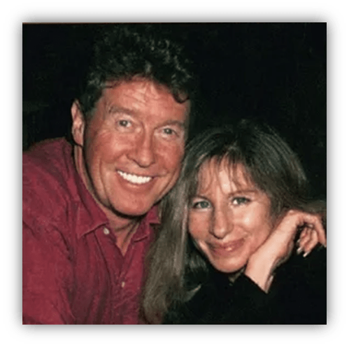 Smiling couple posing together in a dimly lit setting.