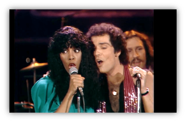 "Two singers performing on stage with microphones, showcasing a lively musical moment."