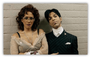 "Two individuals posing together against a textured wall, showcasing unique fashion styles."