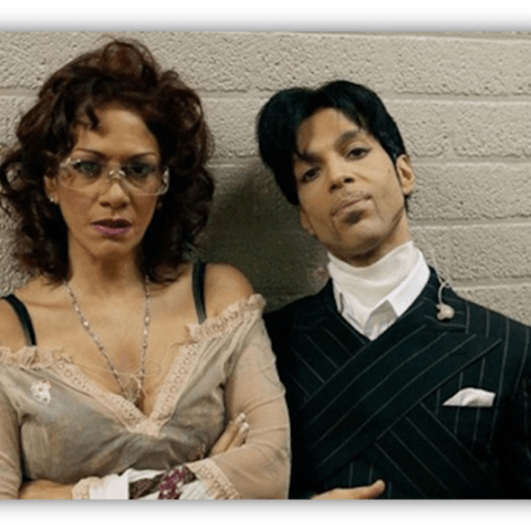 "Two individuals posing together against a textured wall, showcasing unique fashion styles."