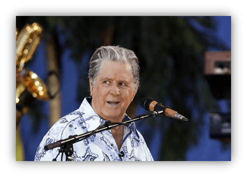 "Legendary musician performing on stage with a microphone."