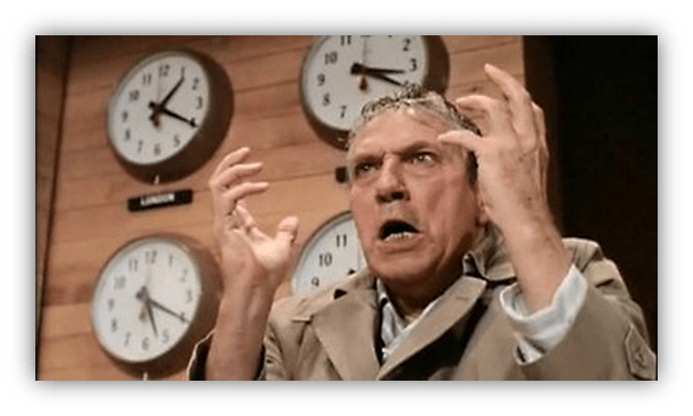 Angry man in a trench coat expressing frustration in a newsroom with multiple clocks.