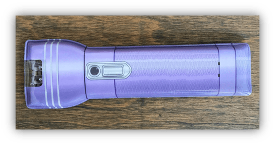 Purple flashlight on wooden surface.