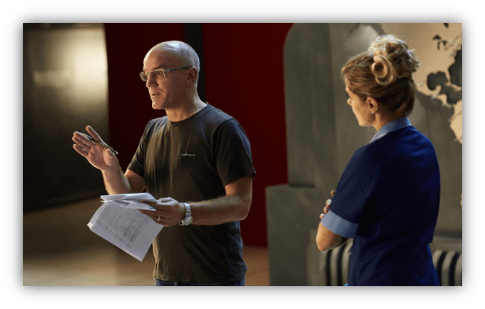 Director discussing a scene with a cast member on set.