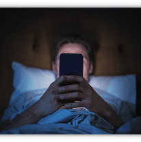 Person in bed using a smartphone at night.