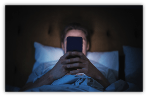 Person in bed using a smartphone at night.