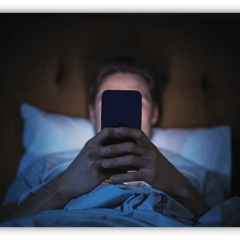 Person in bed using a smartphone at night.