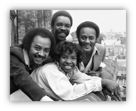 "Vintage black and white photo of a smiling musical group posing together outdoors."