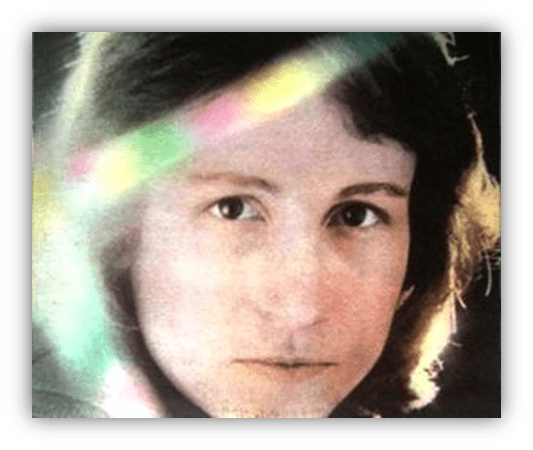 "Close-up of a woman with soft features and a contemplative expression, illuminated by colorful light reflections."