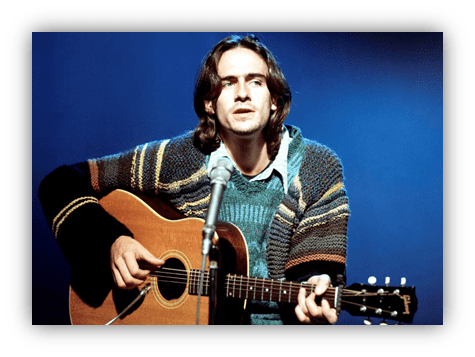 "Musician playing acoustic guitar in a cozy sweater, performing on stage."