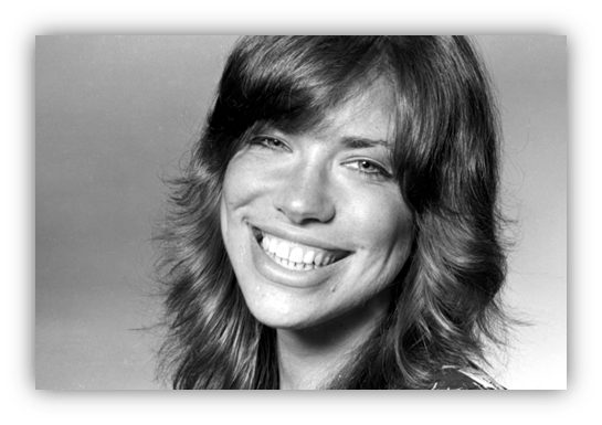 Smiling woman with long hair in black and white portrait.