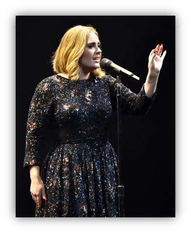 Adele performing live on stage in a sparkling black dress.