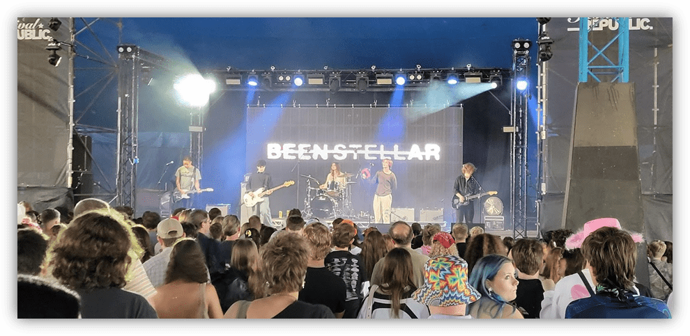 "Live performance by Beenstellar at a music festival with an enthusiastic crowd."