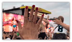 "Audience enjoying a live concert with raised hands and vibrant stage lights."