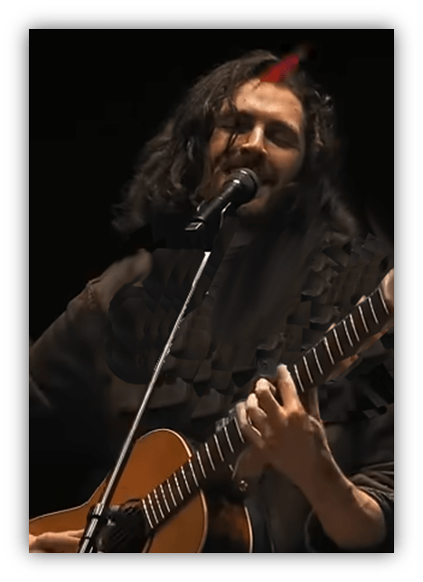 Singer performing live with an acoustic guitar.