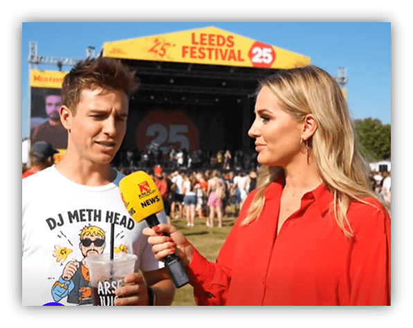 "Interview at Leeds Festival 25 featuring a man in a DJ shirt and a female reporter."