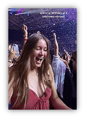 "Joyful concert-goer celebrating her birthday at a lively music event."