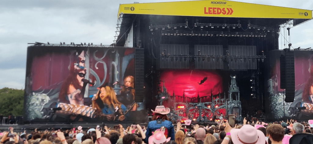 "Live performance at Leeds Festival with vibrant stage visuals and enthusiastic crowd."