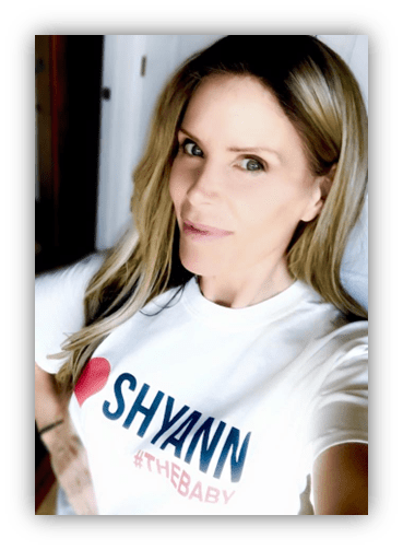 Woman wearing a white t-shirt with "I ❤️ SHYANN #THEBABY" printed on it.