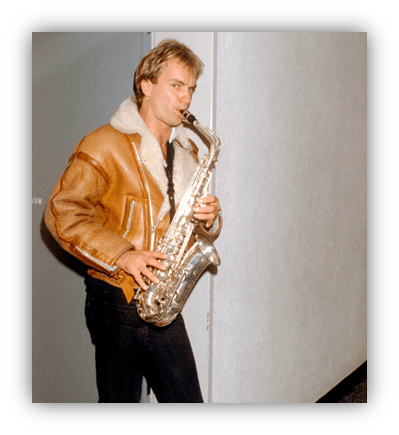 "Man playing saxophone in a brown leather jacket."