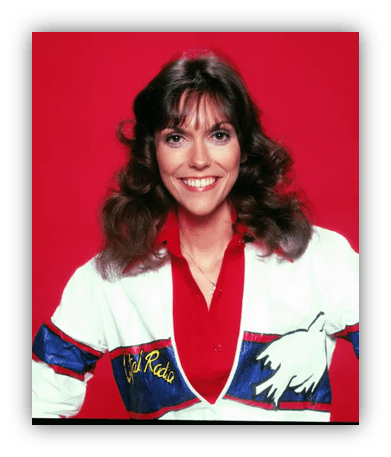 Smiling woman in a colorful jacket against a red background.