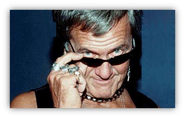 Man with sunglasses and accessories, showcasing a bold fashion style.