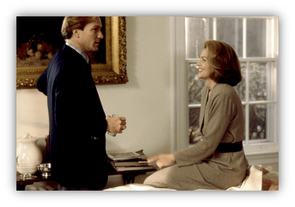 "Two actors in a cozy indoor setting, engaged in a lighthearted conversation."
