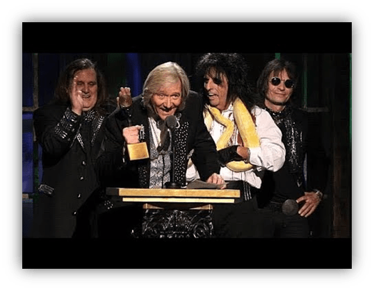 "Musicians celebrating an award acceptance on stage."